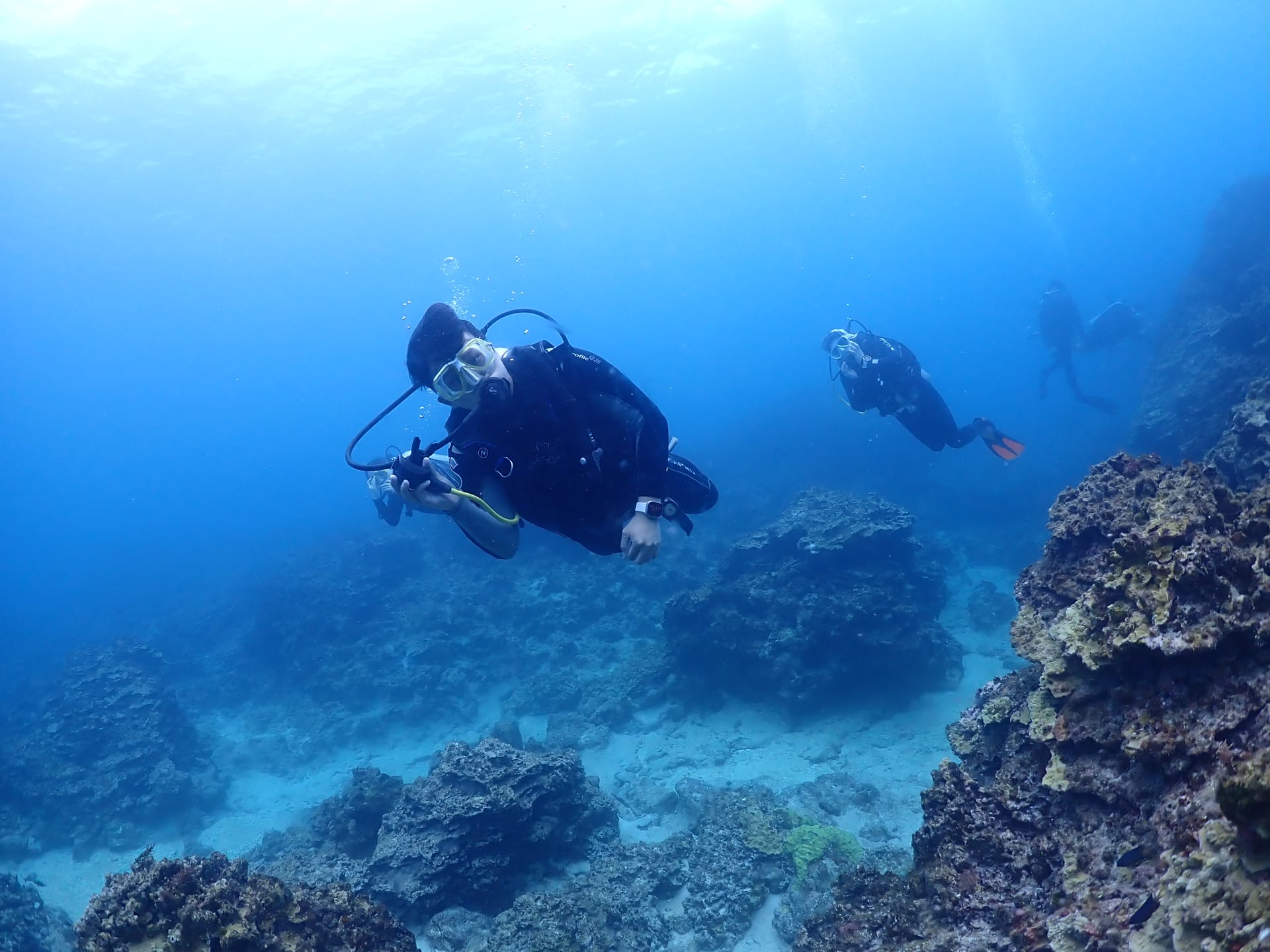 사이판 올레아이 다이빙 중 산호 지형 사이를 지나는 다이버