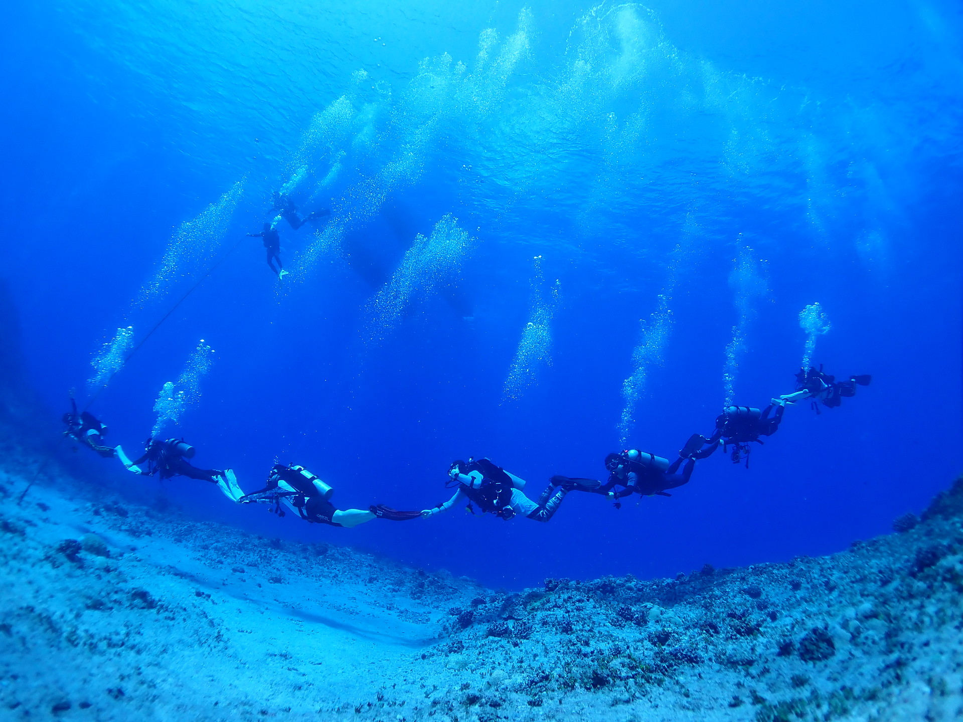 티니안 그로토에서 줄지어 이동하는 다이빙 팀